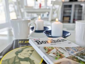 - une table avec un magazine, des bougies et un livre dans l'établissement Holiday Home Greta - 200m from the sea in Bornholm by Interhome, à Vester Sømarken
