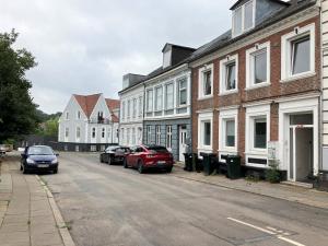 un grupo de coches estacionados en una calle con edificios en Furnished 2 Bedroom Apartment In Kolding, en Kolding