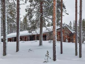 a log cabin in the woods in the snow at Holiday Home Sallan savu e by Interhome in Salla