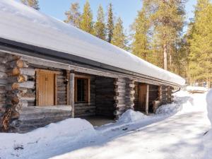 a log cabin with snow on the roof at Holiday Home Sallan savu e by Interhome in Salla
