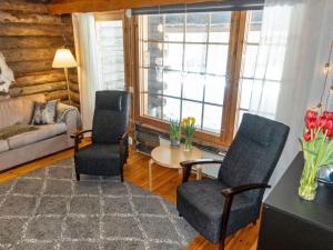 a living room with two chairs and a table at Holiday Home Sallan savu e by Interhome in Salla +6 photos