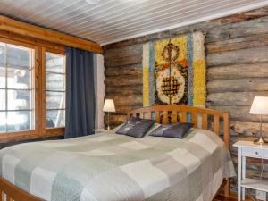 a bedroom with a bed and a wooden wall at Holiday Home Sallan savu e by Interhome in Salla