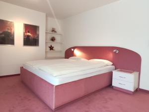 达沃斯Apartment Attika Wohnung Allod Park Haus C 801 by Interhome的卧室里有一张带红色床头板的大床