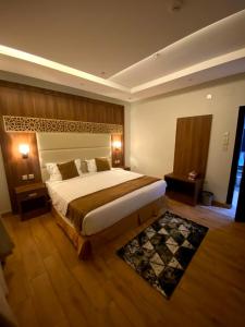 ein großes Schlafzimmer mit einem großen Bett und einem Teppich in der Unterkunft أفنان بارك شقق فندقية in Ta'if