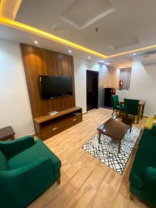 ein Wohnzimmer mit einem Sofa und einem Flachbild-TV in der Unterkunft أفنان بارك شقق فندقية in Ta'if