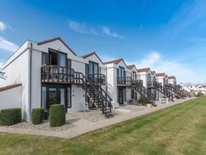 a row of houses with a lawn in front at Apartment Giuliott with parking and shared pool by Interhome in De Haan
