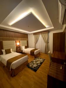 Habitación de hotel con 2 camas y escritorio en أفنان بارك شقق فندقية en Taif
