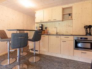 a kitchen with wooden cabinets and a table and chairs at Apartment Glamping Lodge A by Interhome in Ossiach