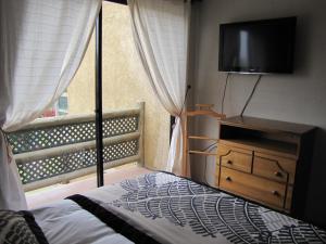 a bedroom with a bed and a dresser with a television at Apart Hotel Gran Pacifico in La Serena +64 photos