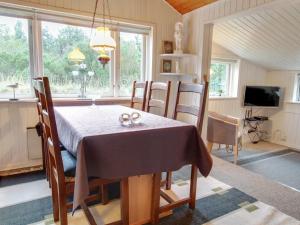 a dining room with a table and chairs and a television at Holiday Home Wimmer - 800m from the sea in Western Jutland by Interhome in Vejers Strand