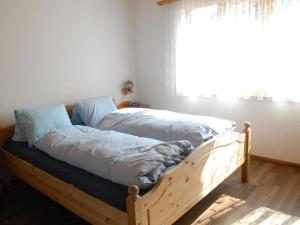 a bedroom with a bed with white sheets and a window at Apartment Calanques by Interhome in Adelboden