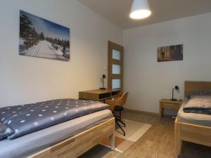 a bedroom with a bed and a desk with a chair at Apartment Kořenov 720-2 by Interhome in Kořenov