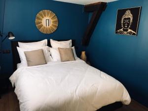 um quarto com uma grande cama branca e uma parede azul em Escale à Fécamp 4 étoiles - garage privé em Fécamp