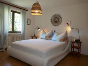 a bedroom with a large white bed with blue pillows at Apartment Casa Lara by Interhome in Olivone