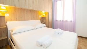 a bedroom with a white bed with towels on it at Welcomely - Sandy House in Putzu Idu