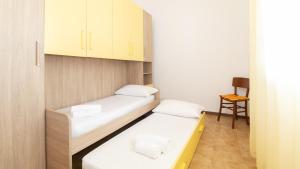 a small room with two beds and a chair at Welcomely - Sandy House in Putzu Idu