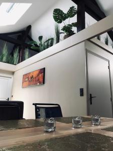 una mesa en una habitación con plantas en la pared en Escale à Fécamp 4 étoiles - garage privé, en Fécamp