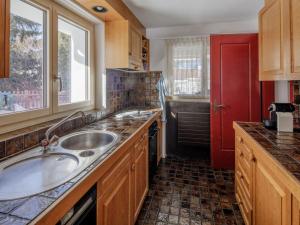 a kitchen with a sink and a red door at Apartment Guarda Val Müller Lärchensitz by Interhome in Lenz