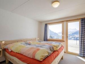 - une chambre avec un lit et une grande fenêtre dans l'établissement Apartment Guarda Val Müller Lärchensitz by Interhome, à Lenz