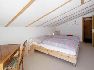 - une chambre avec un lit et un bureau en bois dans l'établissement Apartment Guarda Val Müller Lärchensitz by Interhome, à Lenz