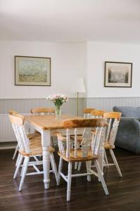 uma mesa de jantar com cadeiras e um vaso de flores em Eala House em Donegal