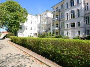 uma sebe em frente a um edifício branco em Apartment Zinnowitzer Hof-5 by Interhome em Zinnowitz
