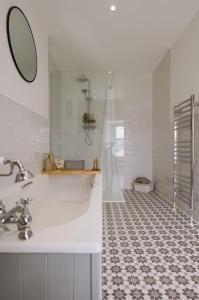 ein weißes Badezimmer mit einem Waschbecken und einem Spiegel in der Unterkunft Eala House in Donegal