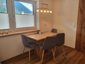 mesa de comedor con 4 sillas y lavamanos en Apartment Bergblick by Interhome, en See