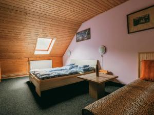 sypialnia z 2 łóżkami i drewnianym sufitem w obiekcie Apartment Kačenka-1 by Interhome w mieście Desná