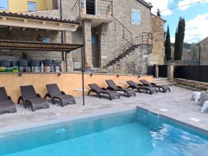 - une piscine avec des chaises longues à côté d'un bâtiment dans l'établissement Casa Jovanin, à Livade