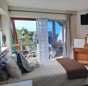 - une chambre avec un lit et une vue sur l'océan dans l'établissement Ryans Surf Cabin, à Jeffreys Bay