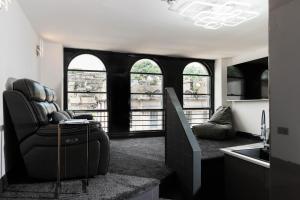 a living room with a couch and some windows at The Arches Apartments Kendal in Kendal
