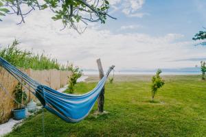 a blue hammock in a field next to the ocean at House by the Sea in Lefkímmi