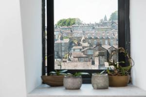 uma janela com vasos de plantas no parapeito da janela em The Arches Apartments Kendal em Kendal