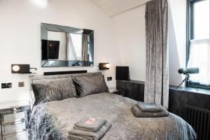 1 dormitorio con 1 cama con 2 toallas en The Arches Apartments Kendal, en Kendal