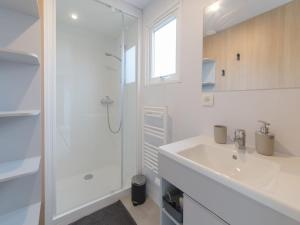 y baño blanco con lavabo y ducha. en Holiday Home secci beach by Interhome, en Bredene