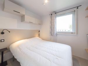 1 dormitorio con cama blanca y ventana en Holiday Home secci beach by Interhome, en Bredene