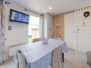 comedor con mesa y TV en la pared en Holiday Home secci beach by Interhome, en Bredene