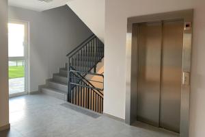 a hallway with a elevator and a staircase at Apartamenty Westerplatte in Jastrzębia Góra