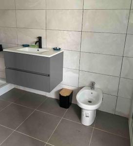 een badkamer met een wastafel en een toilet bij Cozy Apartment in Cotonou
