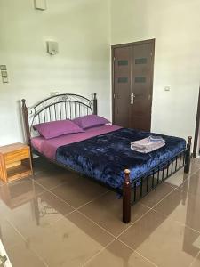 een slaapkamer met een bed met paarse kussens en een deur bij Cozy Apartment in Cotonou