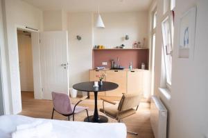 salon ze stołem i krzesłami oraz kuchnię w obiekcie Arbio I Lax Apartments w Lipsku
