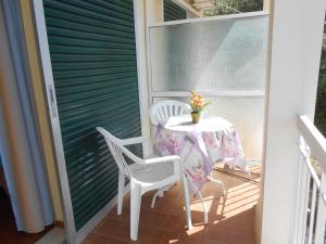 a table and chairs on a porch with a table and flowers at Gregory's Studios in Paleokastritsa