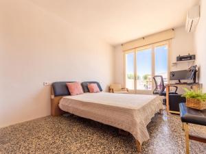 a bedroom with a bed and a large window at Holiday Home Oleg by Interhome in Torredembarra