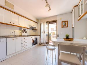 a kitchen with white cabinets and a counter and chairs at Apartment Rosalía by Interhome in Torredembarra