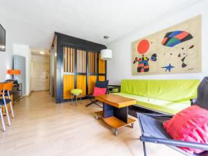 a living room with a green couch and a table at Studio Alboran by Interhome in Salou