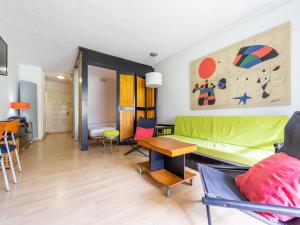 a living room with a green couch and a table at Studio Alboran by Interhome in Salou +14 photos