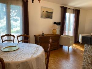 a dining room with a table and chairs and windows at Casa Minnana in Figari