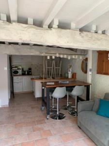 Le Verdier的住宿－Le pigeonnier，厨房以及带桌子和沙发的客厅。