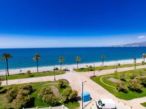 a view of a beach with palm trees and a white van at Apartment Marina by Interhome in Salobreña
